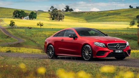 Sleek Red Sports Car on Scenic Road wallpaper