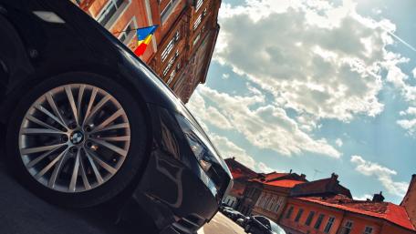 Sleek Black Car Against a Historic Backdrop wallpaper