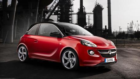 Vibrant Red Sporty Car Against Industrial Background wallpaper