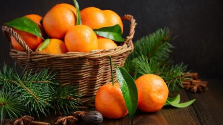 Vibrant Tangerines in a Basket With Greenery wallpaper