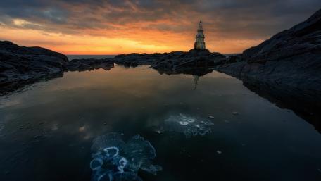 Serene Sunset Over Rocky Shoreline wallpaper