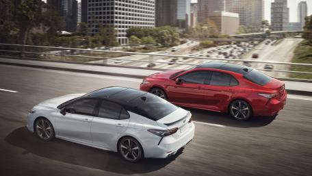 Sleek Cars on the Highway in Urban Setting wallpaper