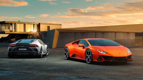 Sleek Lamborghini Pair on a Scenic Sunset Drive wallpaper