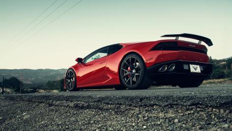 Vibrant Red Lamborghini on a Scenic Road wallpaper