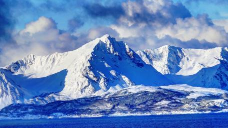Majestic Snow-Capped Mountains Beside Glittering Waters wallpaper