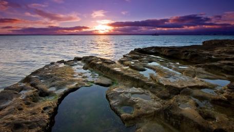Tranquil Sunset Over Rocky Shoreline wallpaper