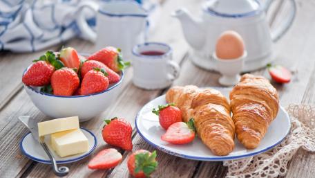 Delightful Breakfast Scene with Croissants and Fresh Strawberries wallpaper