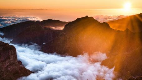 Majestic Sunrise Over Cloudy Mountains wallpaper