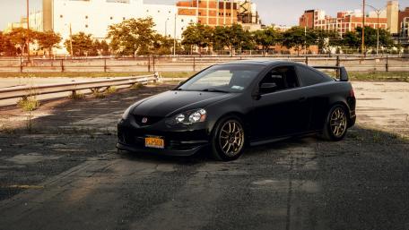 Sleek Black Sports Car in Urban Setting wallpaper
