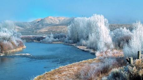 Frozen River in Serene Winter Landscape wallpaper