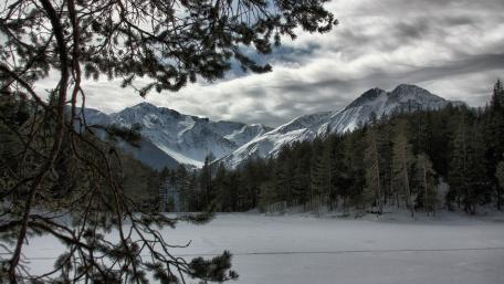 Serene Winter Landscape with Majestic Mountains and Frozen Lake wallpaper