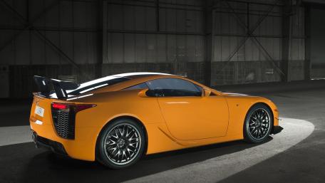 Sleek Orange Sports Car in a Dark Environment wallpaper