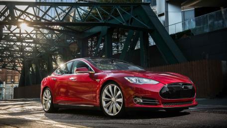 Sleek Red Electric Car Beneath Urban Architecture wallpaper