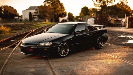 Sleek Black Sports Car in Sunset Glow wallpaper