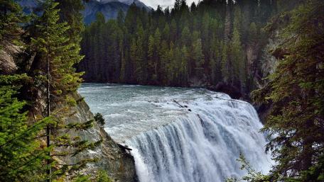 Majestic Waterfall Cascading into Serene Waters wallpaper