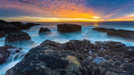 Serene Sunset over Rocky Shoreline wallpaper