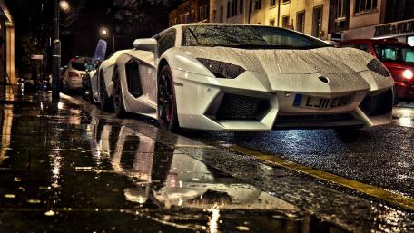 Sleek Luxury Car in Rainy Night Setting wallpaper