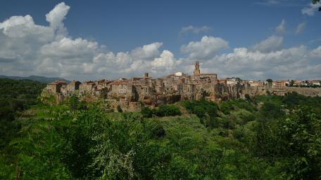 Quaint Hilltop Village Surrounded by Lush Greenery wallpaper