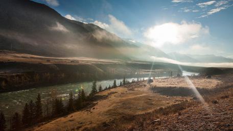 Breathtaking River Valley at Sunrise with Misty Mountains wallpaper