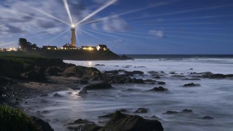Lighthouse Illuminating Serene Coastal Nightscape wallpaper