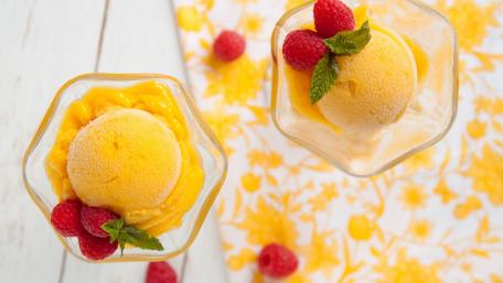 Delicious Mango Sorbet with Fresh Raspberries and Mint Garnish wallpaper