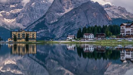 Serene Mountain Reflections in a Picturesque Cityscape wallpaper