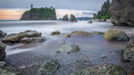 Serene Coastal Landscape with Timeless Rocks and Gentle Waves wallpaper
