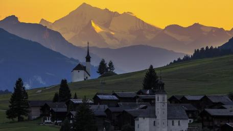 Majestic Mountain Sunrise Over Serene Village wallpaper