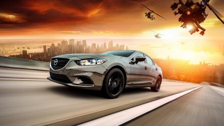 Sleek Mazda Racing Towards Sunset Skyline wallpaper