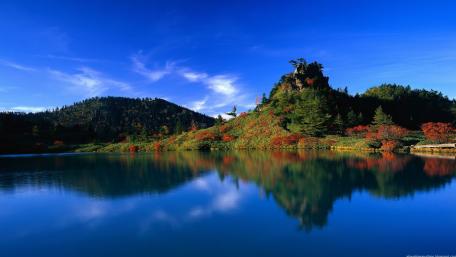 Serene Lake Surrounded by Colorful Forests wallpaper