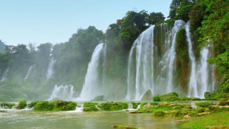 Majestic Waterfalls Cascading Through Lush Greenery wallpaper