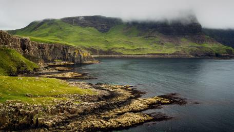 Serene Coastal Landscape Under Misty Clouds wallpaper