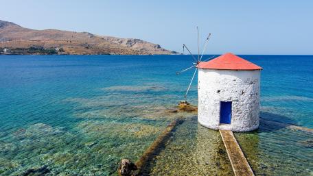 Serene Coastal Windmill by the Clear Waters wallpaper