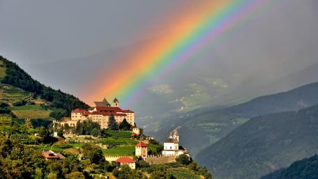 Serene Castle Under a Vibrant Rainbow wallpaper