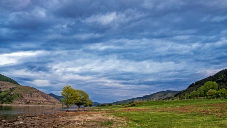 Serene Valley Under Thunderous Skies wallpaper