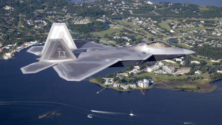 Fighter Jet Soaring Over Serene Landscape wallpaper