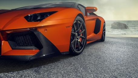 Sleek Orange Sports Car on a Coastal Road wallpaper