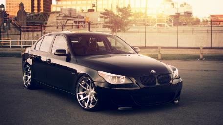 Sleek Black BMW in Urban Sunset Glow wallpaper