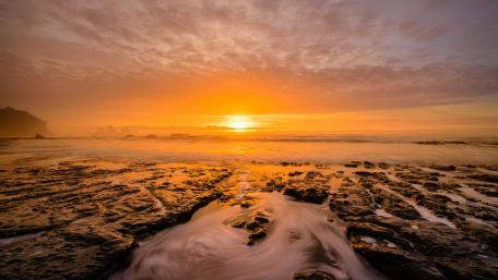 Golden Sunrise Over Tranquil Shoreline wallpaper