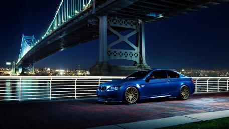 Sleek Blue Car Under a Luminous Bridge wallpaper