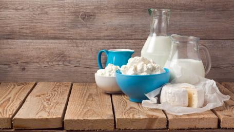 Delicious Dairy Products Displayed Artfully on Wooden Surface wallpaper