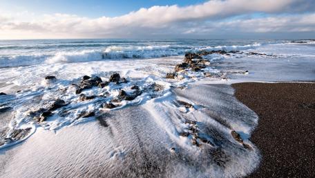 Gentle Waves Embrace the Shoreline in Serenity wallpaper