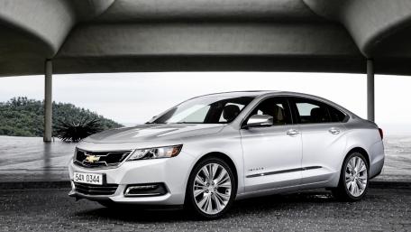 Sleek Silver Sedan Under Modern Architecture wallpaper
