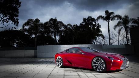 Sleek Red Luxury Coupe in a Dramatic Setting wallpaper