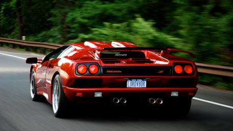 Sleek Red Lamborghini on the Open Road wallpaper