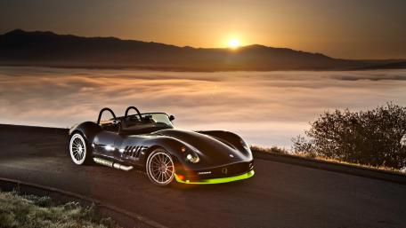 Sleek Sports Car at Sunrise Over Clouds wallpaper
