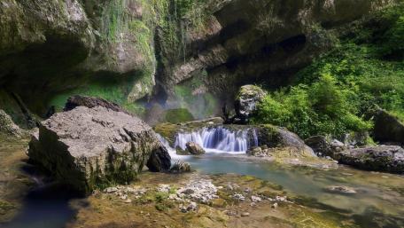 Serene Waterfall in a Lush Green Landscape wallpaper
