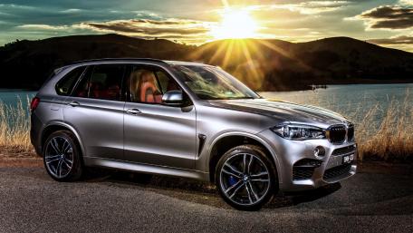 Sleek BMW X5 by the Sunset Shoreline wallpaper