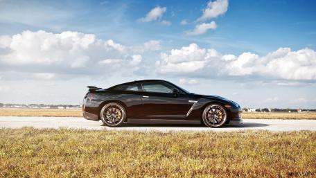 Sleek Black Sports Car on Open Road wallpaper
