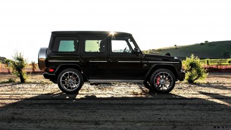 Sleek Black Luxury SUV on Scenic Terrain wallpaper